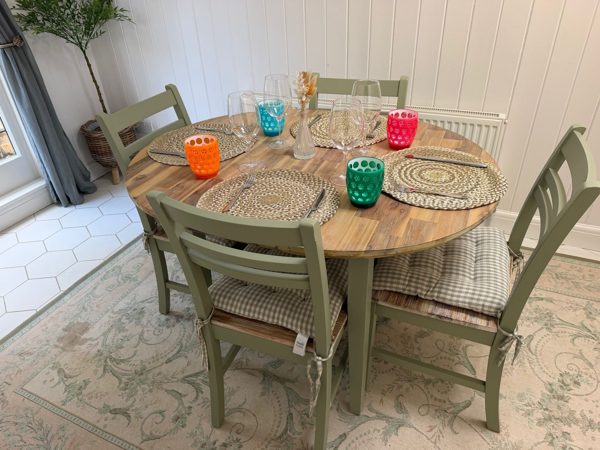 Breakfast room table laid with colourful glasses at Glebe Cottage, Bledington