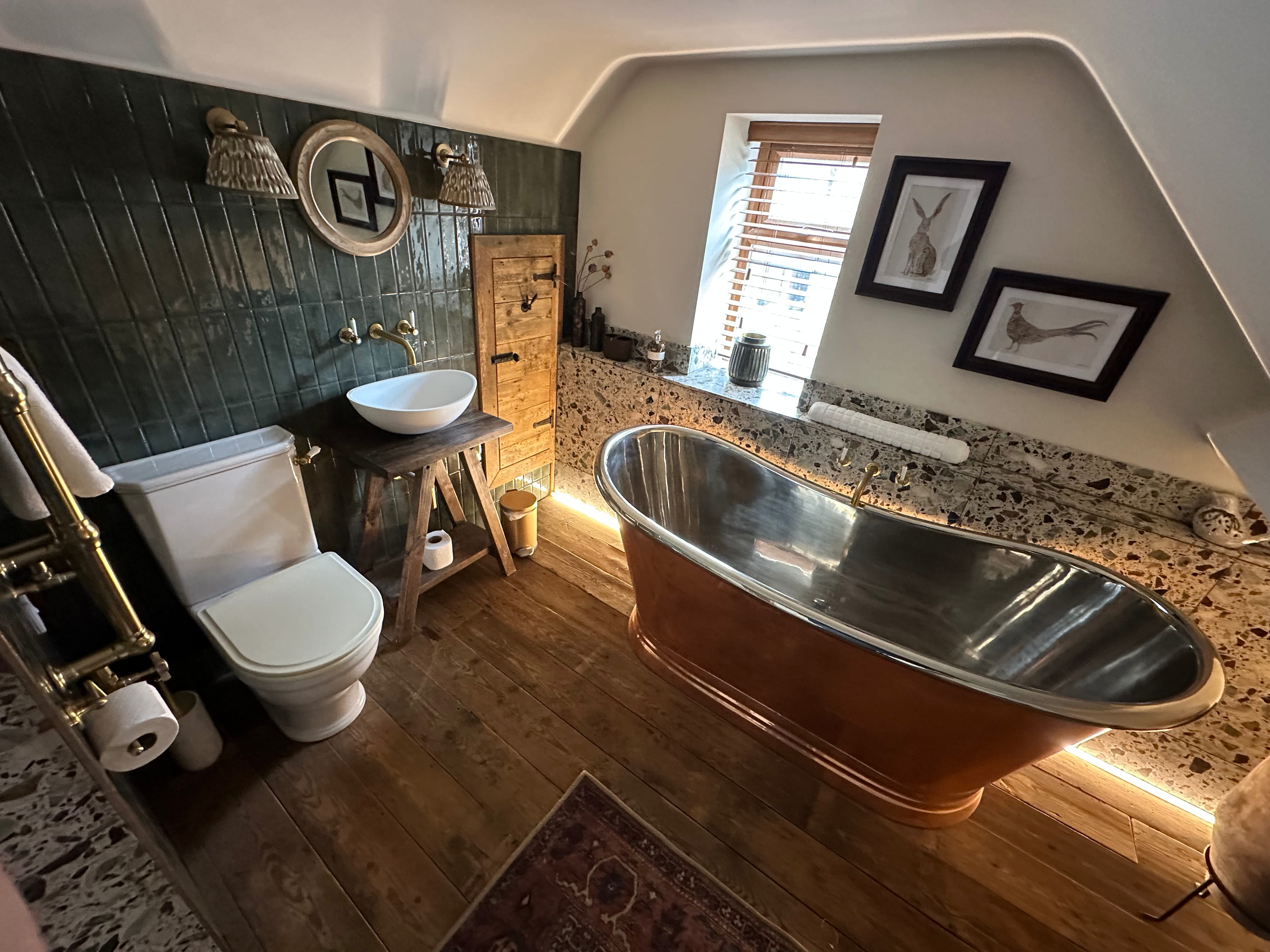 Copper bathtub in the bathroom at Glebe Cottage, a Grade II listed Cotswold cottage