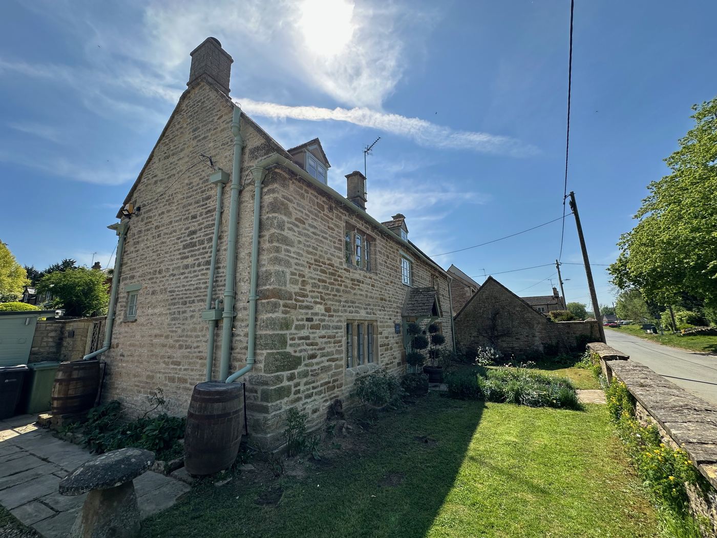 Exterior side view of Glebe Cottage, a Grade II listed Cotswold stone holiday cottage in Bledington, Oxfordshire