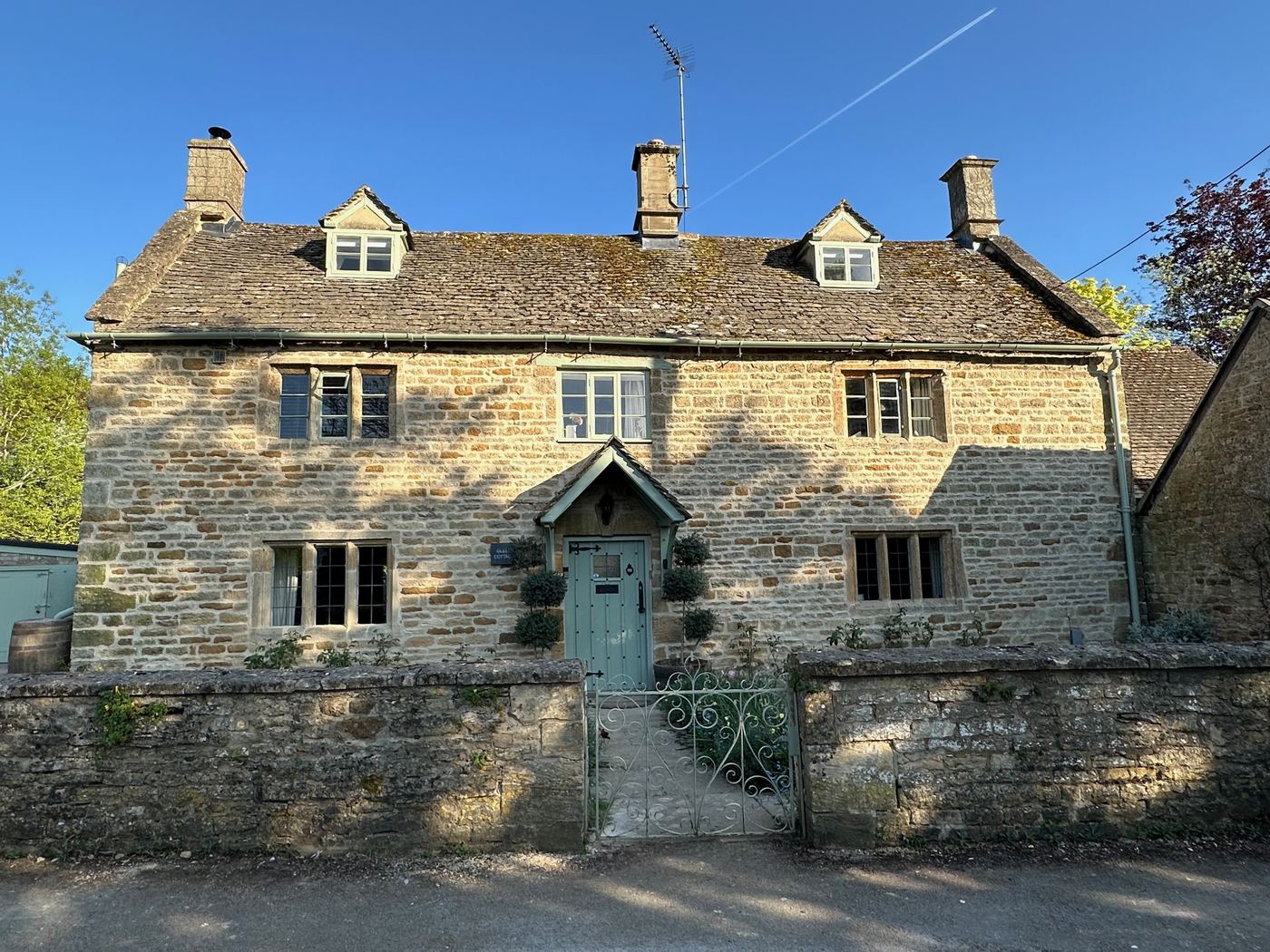 Front exterior of Glebe Cottage at golden hour, Bledington, Oxfordshire