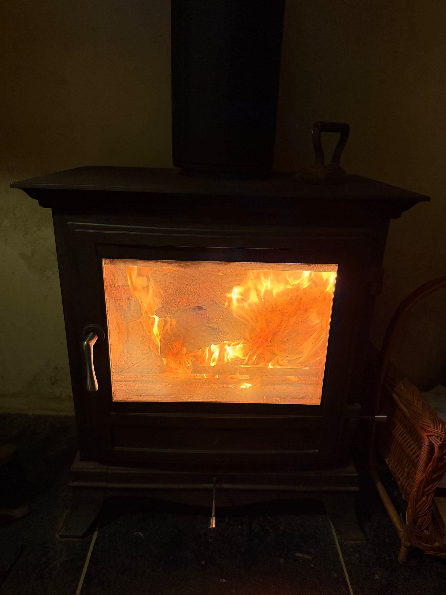Log burner with roaring fire in the snug at Glebe Cottage, Bledington