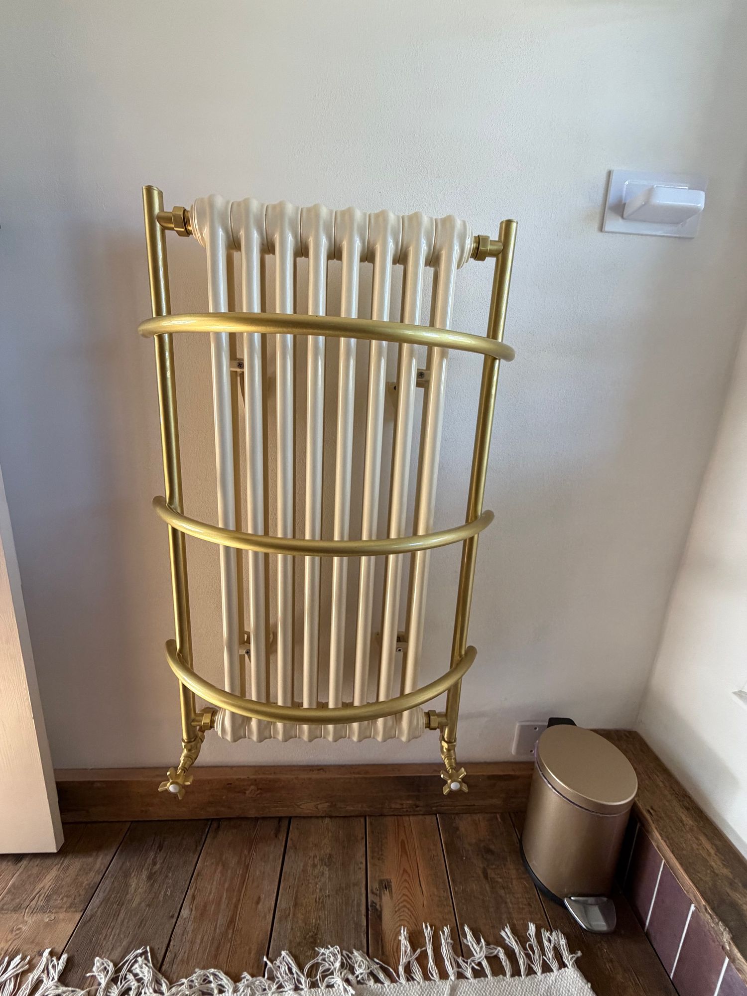 Brass heated towel radiator in the main bathroom at Glebe Cottage, Bledington